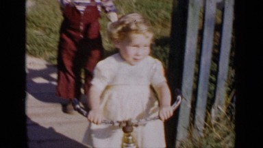 1951: two children play outside in the summer weather wearing big smiles