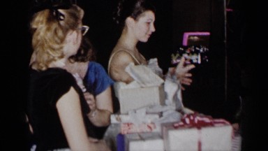 1954: lady showing the purse to all NEW YORK