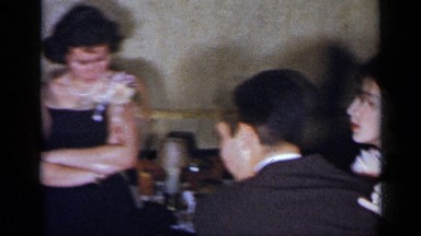 1954: a man and woman dance skillfully to a quick beat while others look on.
