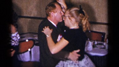 1954: man and woman with cat eye glasses dancing at a party NEW YORK