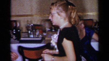 1954: a girl and a man dancing at a wedding reception, with a little boy running