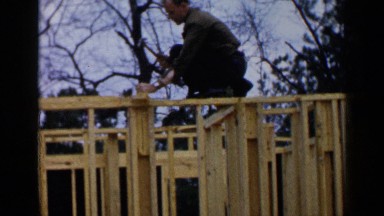 1957: a carpenter busy at work building a cage early morning in the forest.