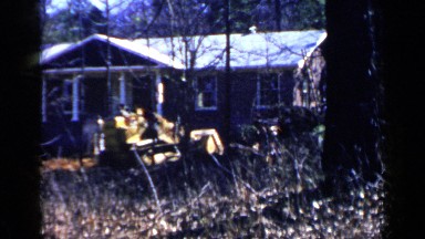 1957: worker cleaning the front place of house for moving to the house.