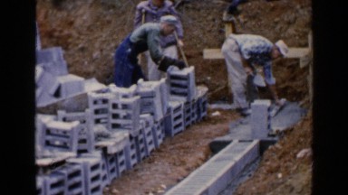 1957: workers prepare yard for new construction by laying blocks BIRMINGHAM