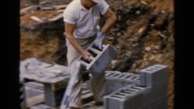 1957: a man alone taking and arrange the cement bricks