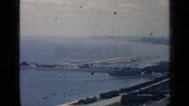 1957: video of the view of a barge or dam along the river and the sights around