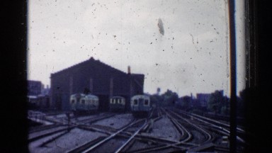 1958: small white and blue train driving away from a station CHICAGO
