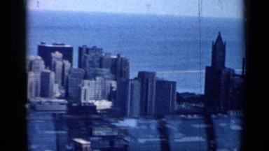 1958: An Avenue Breaks a City Skyline of Rectangular Buildings by an Ocean