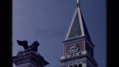1960: ornate steeple of a building or church with winged statue overlooking.