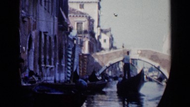 1960: people are cleaning the water at front of apartments and a bridge