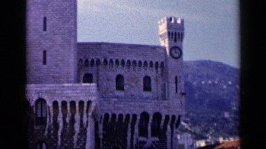 1960: a palace is seen with a clock attached to its pillar with mountains