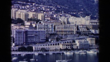 1960: a beautiful scenery with mountains, buildings and a ocean with boats