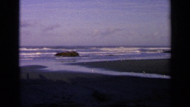 1963: waves crash onto a sandy beach at low tide near dusk CALIFORNIA