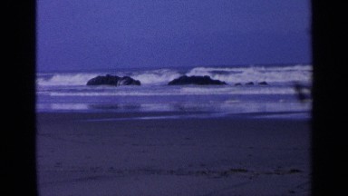 1963: footage of waves crashing over rocks on a beach. CALIFORNIA