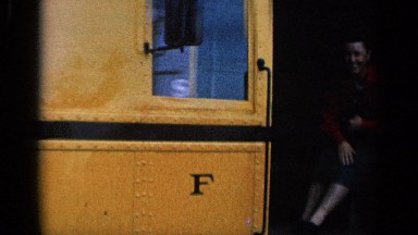 1963: yellow color train engine moving backward in the track with a lady inside