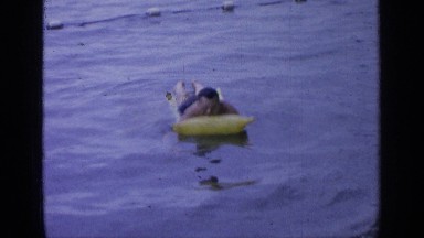 1964: a man on an air mattress in a swimming pool. GREENWOOD LAKE NEW YORK
