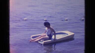 1964: a woman enjoys her vacation by sunbathing along the shore of the water