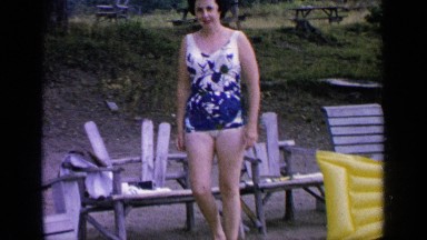 1964: woman in swimwear walking and posing for the camera. GREENWOOD LAKE
