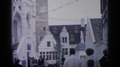1964: people walking down the street amid large buildings on either sides