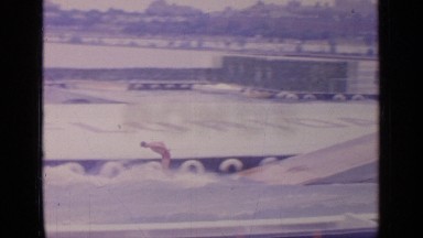1964: a water skier does tricks and waves to the crowd while being pulled