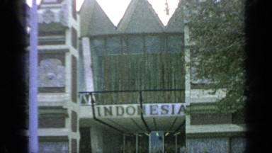 1964: people walking in front of some kind of ship in indonesia
