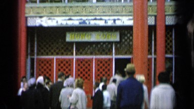 1964: various people walking into a building with asian words on the front sign