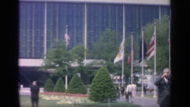 1964: the front yard of a magnificent building with beautiful garden and flags