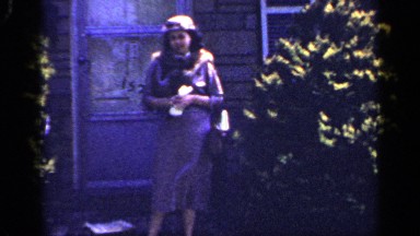 1965: a woman trying to pose for a picture in a very windy and sunny day