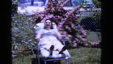 1965: Woman Sunbathing in Lawn Chair on Long Island Front Yard