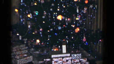 1965: the camera pans up the length of a well-decorated and lit christmas tree