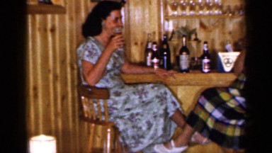 1965: a trio smiles for the camera and enjoys cocktails at a bar. LONG ISLAND