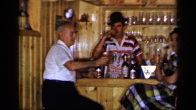 1965: an old couple sitting at the bar and having their wine for a celebration
