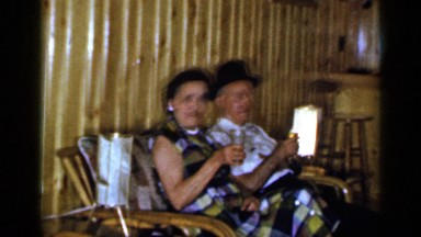 1965: two old couple sitting together and drinking another man sitting nearby