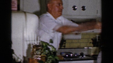 1965: family spending time in kitchen, husband and wife throw a package