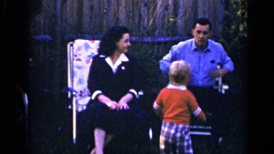 1965: a son talks to his father in the back garden while his mother watches on.
