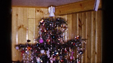 1965: a beautifully decorated and illuminated christmas tree inside the room