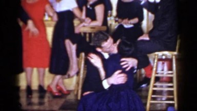 1966: well dressed couple kissing at a party. MINEOLA NEW YORK