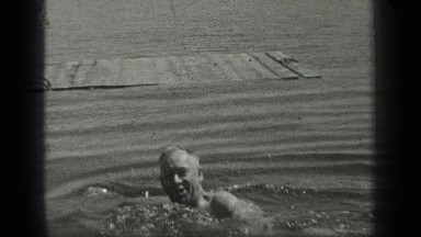 1939: a senior citizen enjoying by swimming in a lake to beat the heat LONG LAKE