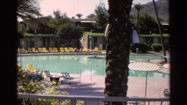 1968: footage of a couple on deck chairs at a poolside resort. SCOTTSDALE