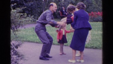 1961: A Couple Play With Their Children Outdoors On The Grass SWITZERLAND