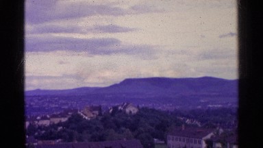1961: view of mountains and an old town in the foreground SWITZERLAND