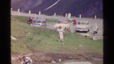 1961: A Woman Runs Up a Hill While a Man Takes a Sip from a Cup, Switzerland