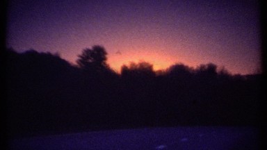 1979: orange glow of the sun appears above dense skyline of tree tops ITHACA