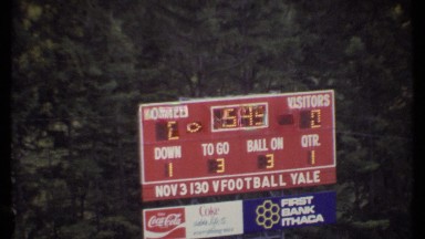 1979: a local football team playing on a field with a scoreboard above ITHACA