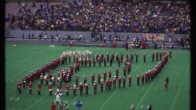 1979: a marching band performing on a football field in front of a crowd ITHACA