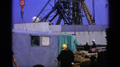1970: Construction Workers on Site by a Blue Building United Kingdom