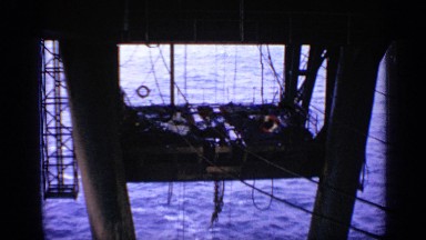 1970: oil rigging deck is suspended above the ocean by cables and scaffolding.