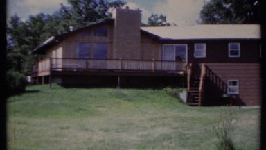 1971: two-story home has large deck wrapping around corner with staircase