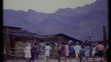 1971: a group of people gathered on front of small buildings and huts CALIFORNIA