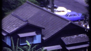 1969: aerial footage of suburban rooftops surrounded by trees. THAILAND